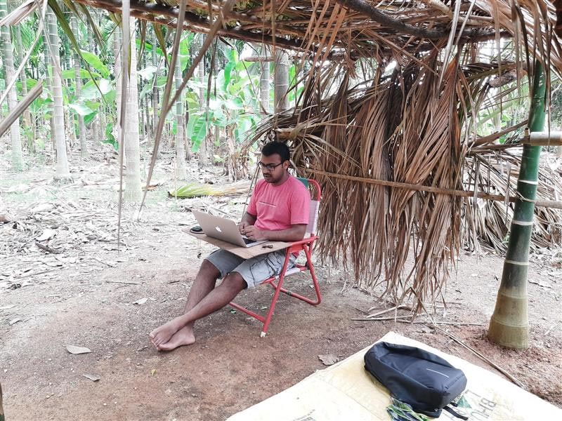 Vinayak Kallambi working under a hut.
