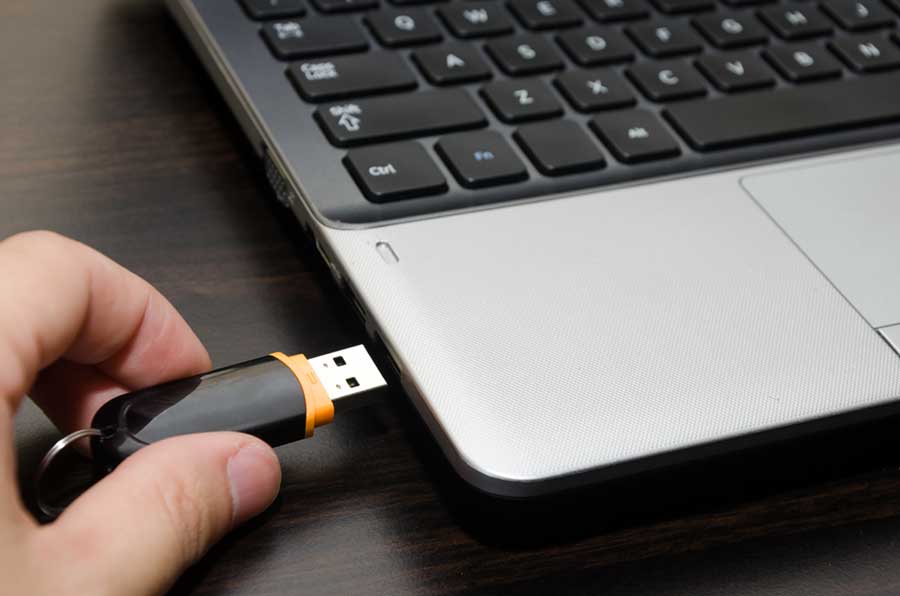 USB drive inserted into a laptop port.